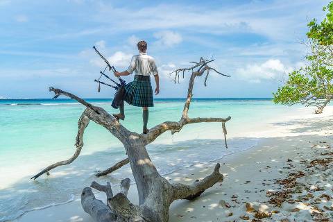 Homem que viaja pelo mundo com gaita de fole, usa kilt até nas Ilhas Maldivas